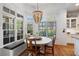 Sunlit dining area featuring a charming breakfast nook with bench seating, a round table, and large windows at 4675 Lakeway Pl, Alpharetta, GA 30005
