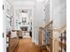 Hallway with hardwood floors leading to an open living area with a fireplace and a bench at 4675 Lakeway Pl, Alpharetta, GA 30005