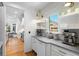 A bright kitchen with white cabinets, stainless steel appliances, hardwood floors, and open shelving for a modern look at 4675 Lakeway Pl, Alpharetta, GA 30005