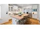 This kitchen boasts stainless steel appliances, an island with seating and cabinets, and beautiful hardwood floors throughout at 4675 Lakeway Pl, Alpharetta, GA 30005