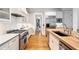 Spacious kitchen boasts stainless appliances, custom cabinets, and hardwood floors, with a view to other rooms at 4675 Lakeway Pl, Alpharetta, GA 30005