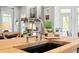 The kitchen features a wood top island with a black sink and a stainless steel faucet, complemented by neutral-toned decor at 4675 Lakeway Pl, Alpharetta, GA 30005