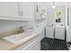 Well-lit laundry room features modern washer/dryer, black tile floor and ample storage space at 4675 Lakeway Pl, Alpharetta, GA 30005