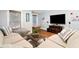 Living room with a neutral-colored sectional sofa, decorative pillows, and views to backyard at 4675 Lakeway Pl, Alpharetta, GA 30005