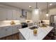 Bright kitchen boasts a large island, pendant lighting, quartz counters, and stainless steel appliances at 107 Iveybrooke Ln # 58, Alpharetta, GA 30009