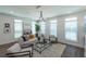Bright and open living room featuring large windows, modern chandelier, and stylish decor at 107 Iveybrooke Ln # 58, Alpharetta, GA 30009