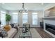 Comfortable living room with fireplace, wood flooring, modern chandelier and large windows allowing ample natural light at 107 Iveybrooke Ln # 58, Alpharetta, GA 30009