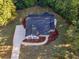 An aerial view shows a house with blue shutters, surrounded by lush trees and a manicured front lawn at 124 Williams Blf, Mcdonough, GA 30252