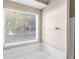 Bathroom with soaking tub, tiled walls and large window providing natural light at 124 Williams Blf, Mcdonough, GA 30252