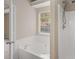 Bright bathroom with a soaking tub, a separate shower, and a large window at 124 Williams Blf, Mcdonough, GA 30252