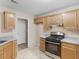 Traditional kitchen design with wooden cabinetry, tile flooring, and stainless steel gas range at 124 Williams Blf, Mcdonough, GA 30252