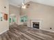 Bright living room with fireplace, vaulted ceiling, ceiling fan, and views to exterior at 124 Williams Blf, Mcdonough, GA 30252