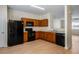 Open concept kitchen with black appliances, wood cabinets, and a breakfast bar, seamlessly connected to the living space at 2419 Ivey Crest Cir, Tucker, GA 30084