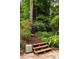 Wood steps lead to a secluded area surrounded by trees, shrubs and lush foliage at 4228 Durham Cir, Stone Mountain, GA 30083