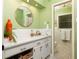 Fresh bathroom with a round mirror, bright green walls, and white tile flooring at 4228 Durham Cir, Stone Mountain, GA 30083