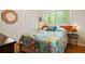 Inviting bedroom featuring a large window, leafy-patterned bedding, and an 