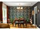 Elegant dining room with ornate wallpaper, statement lighting, and glass-topped dining table at 4228 Durham Cir, Stone Mountain, GA 30083