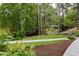 Scenic view of the home nestled amongst mature trees, with a charming walkway leading to the property at 4228 Durham Cir, Stone Mountain, GA 30083