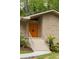 Close-up of the bright orange double front doors, contrasting stone facade, and steps leading to the welcoming entrance at 4228 Durham Cir, Stone Mountain, GA 30083