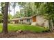 Charming home featuring a stone facade, updated windows, landscaped yard, and a welcoming, bright orange front door at 4228 Durham Cir, Stone Mountain, GA 30083