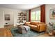 Comfortable living room with hardwood floors, a leather sofa, stylish shelving, and bright natural light at 4228 Durham Cir, Stone Mountain, GA 30083