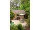 View of the home's exterior with a pool, outdoor dining, and BBQ area surrounded by greenery at 4228 Durham Cir, Stone Mountain, GA 30083