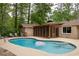 Serene backyard with a spacious pool, lush trees, and a charming screened-in porch at 4228 Durham Cir, Stone Mountain, GA 30083