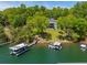 This aerial view shows a waterfront property, showcasing a private dock and lush green surroundings at 5635 Cherokee Trce, Cumming, GA 30041