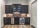 Wet bar with stainless appliances, brick backsplash, and dark cabinets at 5635 Cherokee Trce, Cumming, GA 30041