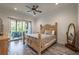 Cozy bedroom with wood-look flooring, ceiling fan, and a sliding door to a patio with outdoor seating at 5635 Cherokee Trce, Cumming, GA 30041
