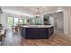 Kitchen island featuring a sink and quartz countertop, adjacent to a dining area and living space at 5635 Cherokee Trce, Cumming, GA 30041