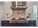 Range and backsplash with a stainless steel hood and custom tile work at 5635 Cherokee Trce, Cumming, GA 30041