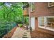 Brick home exterior with a stone pathway and lush greenery, creating a private backyard oasis at 1016 Lenox Ne Crst, Atlanta, GA 30324