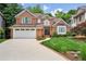 Charming two-story brick home with manicured lawn, attached garage, and inviting curb appeal at 1016 Lenox Ne Crst, Atlanta, GA 30324