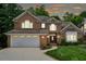 Charming two-story brick home with manicured lawn, attached garage, and inviting curb appeal at dusk at 1016 Lenox Ne Crst, Atlanta, GA 30324