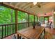 Inviting screened-in porch featuring wood floors, ceiling fans, and wood table for outdoor living at 1016 Lenox Ne Crst, Atlanta, GA 30324