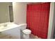 Cozy bathroom featuring a vanity with sink, toilet, and shower with a red curtain for added privacy at 40 Templeton Ln, Villa Rica, GA 30180