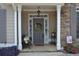 Charming front entrance featuring a decorative wreath, bench, and colorful flower arrangements at 40 Templeton Ln, Villa Rica, GA 30180