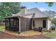 Charming home exterior featuring a screened porch surrounded by gravel and mature trees at 40 Templeton Ln, Villa Rica, GA 30180