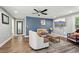 Comfortable living room with hardwood floors, ceiling fan, a blue accent wall, and lots of natural light at 2015 Cascade Sw Rd, Atlanta, GA 30311
