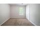 Vacant bedroom showing neutral walls, carpet flooring, and a window inviting natural light at 3777 Oakland Spring Ct, Snellville, GA 30039