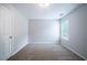 Empty bedroom with neutral walls and carpet features a window and closet door at 3777 Oakland Spring Ct, Snellville, GA 30039