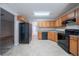 Galley kitchen with black appliances, light wood cabinets, and neutral flooring at 3777 Oakland Spring Ct, Snellville, GA 30039