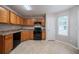 Bright kitchen with wood cabinets and black appliances offers ample counter space at 3777 Oakland Spring Ct, Snellville, GA 30039