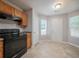 Corner view of kitchen with wood cabinets, black appliances, tile floors and door to outside at 3777 Oakland Spring Ct, Snellville, GA 30039