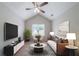 Comfortable living room featuring a ceiling fan, large screen television, and neutral tones at 3777 Oakland Spring Ct, Snellville, GA 30039