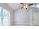 Spacious living room with vaulted ceiling, ceiling fan, tiled floor, and large window for abundant natural light at 3777 Oakland Spring Ct, Snellville, GA 30039