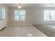An empty living room with tiled area adjacent to the carpeted area has ample lighting from the windows at 3856 Vine Stone Dr, Lithonia, GA 30038
