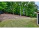 Sloped backyard featuring a mix of lawn and wooded area for privacy, with partial home view at 5250 Briarstone Ridge Way, Alpharetta, GA 30022