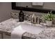 Close-up of a bathroom vanity featuring granite countertops, a white sink, and a framed mirror at 5250 Briarstone Ridge Way, Alpharetta, GA 30022